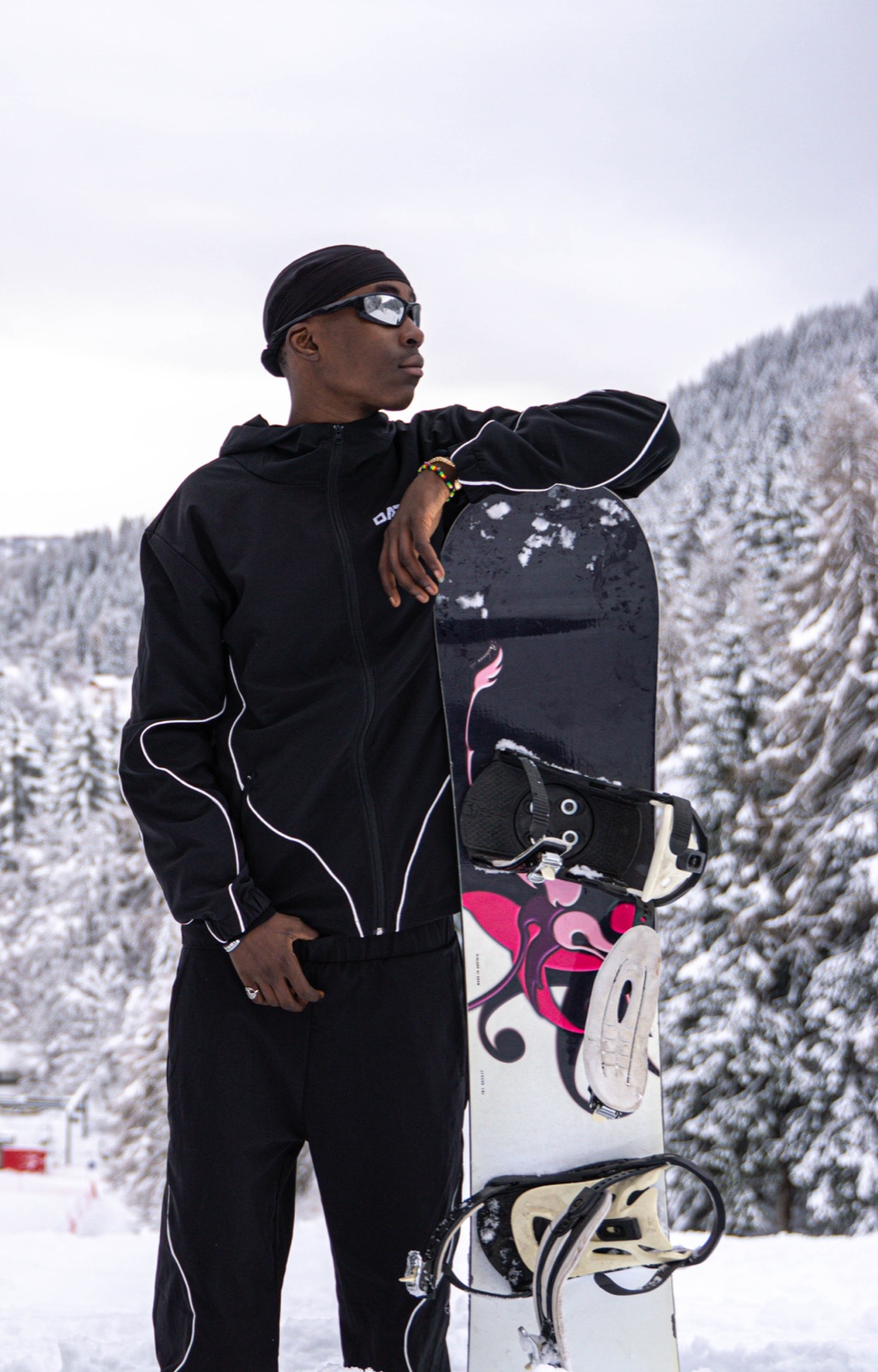 Un ragazzo appoggiato alla tavola da snowboard