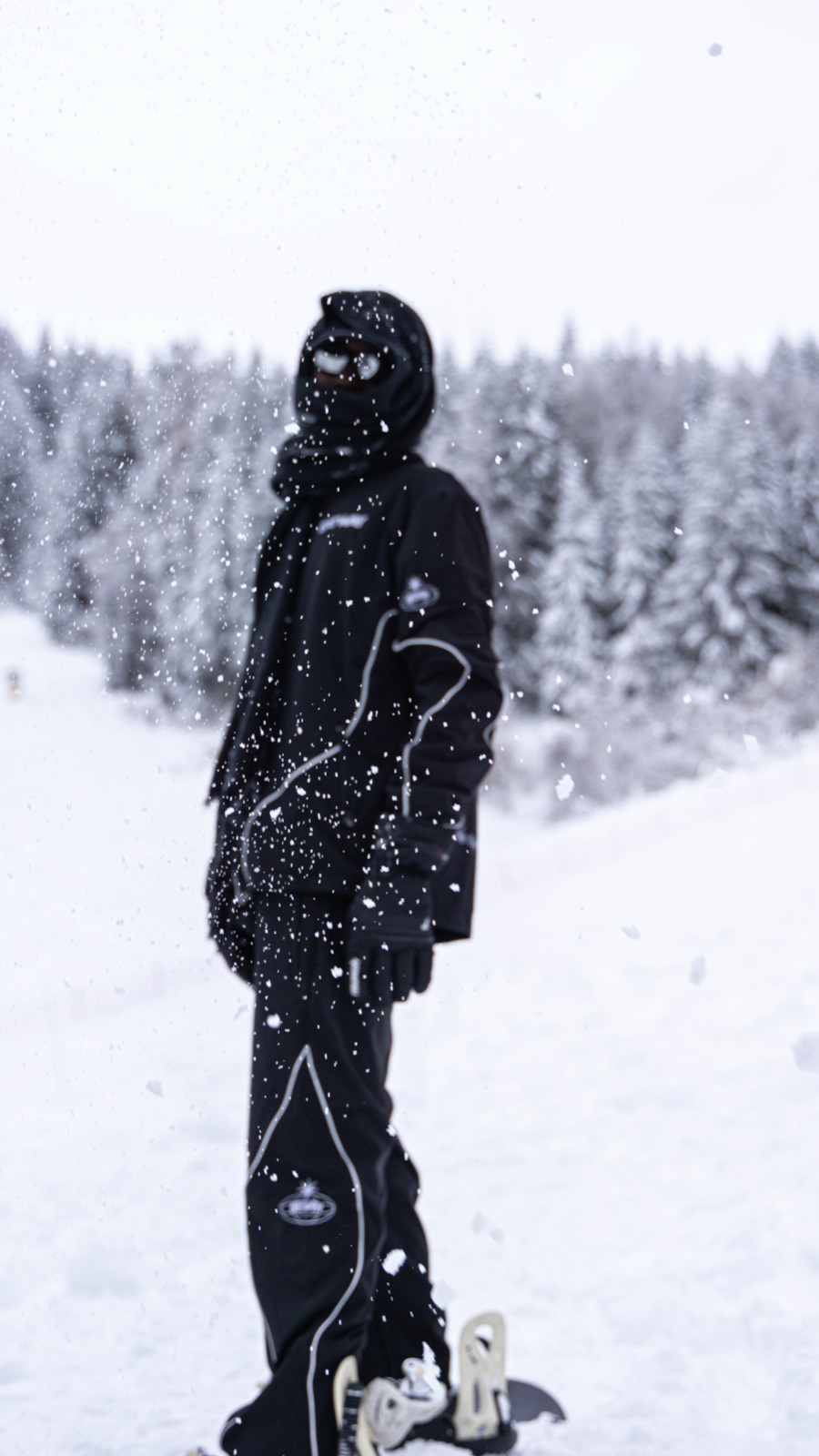 Una figura in tuta nera nella neve, di profilo