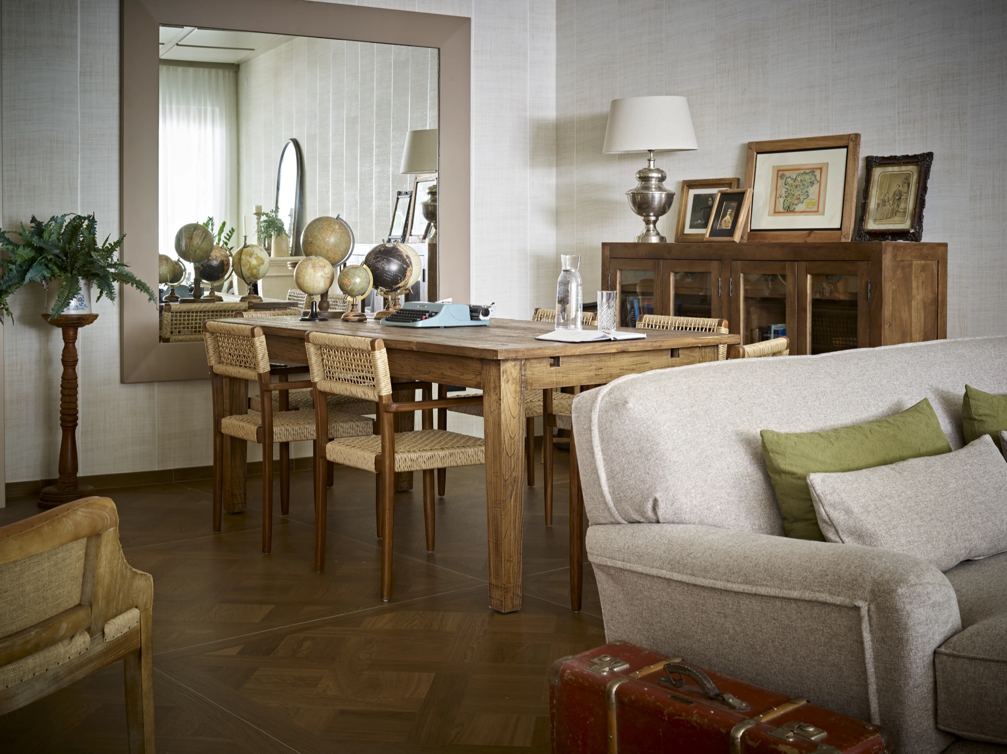 La sala dell'Hotel America con il tavolo in legno e i mappamondi
