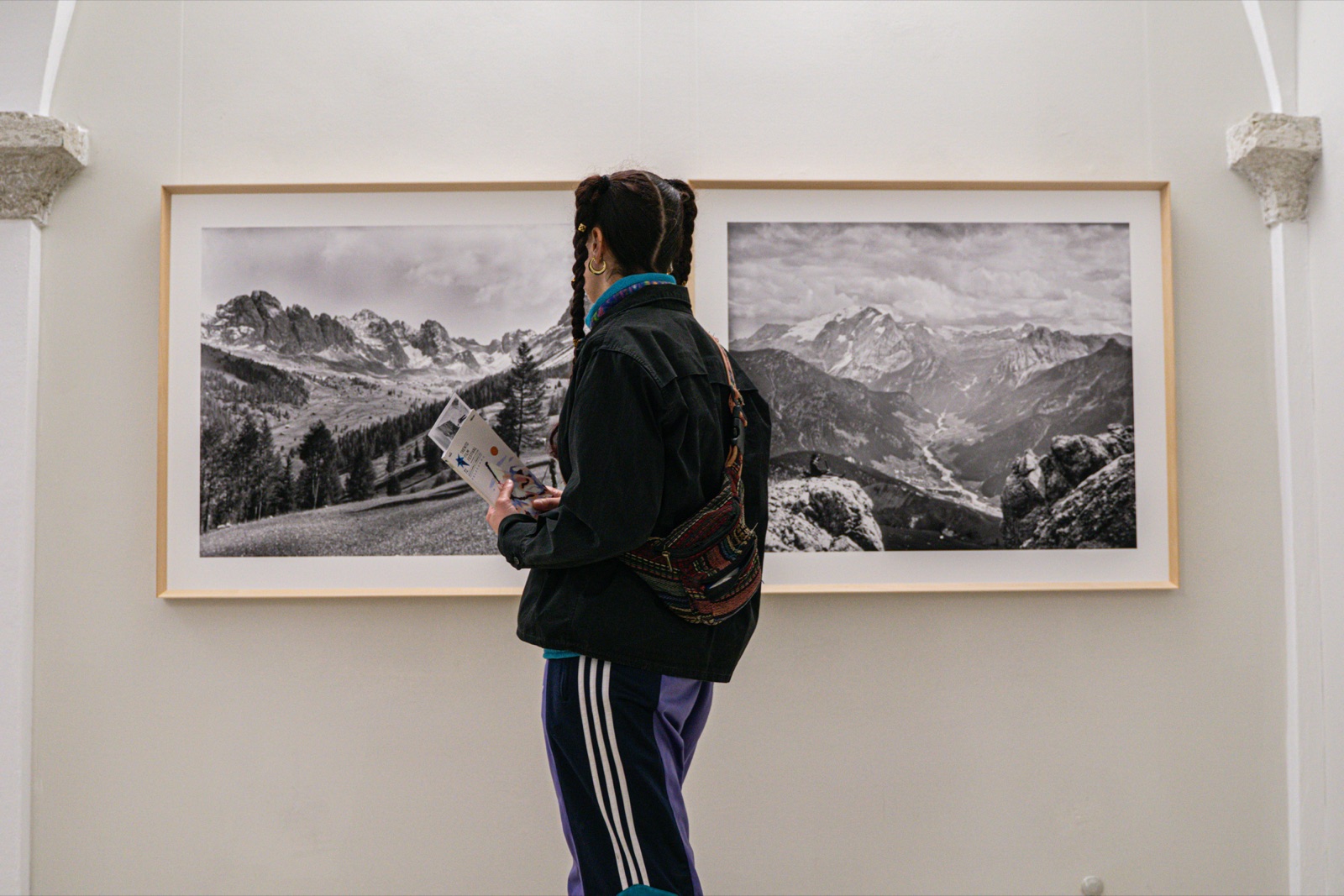 Un visitatore davanti alle foto di montagna della mostra