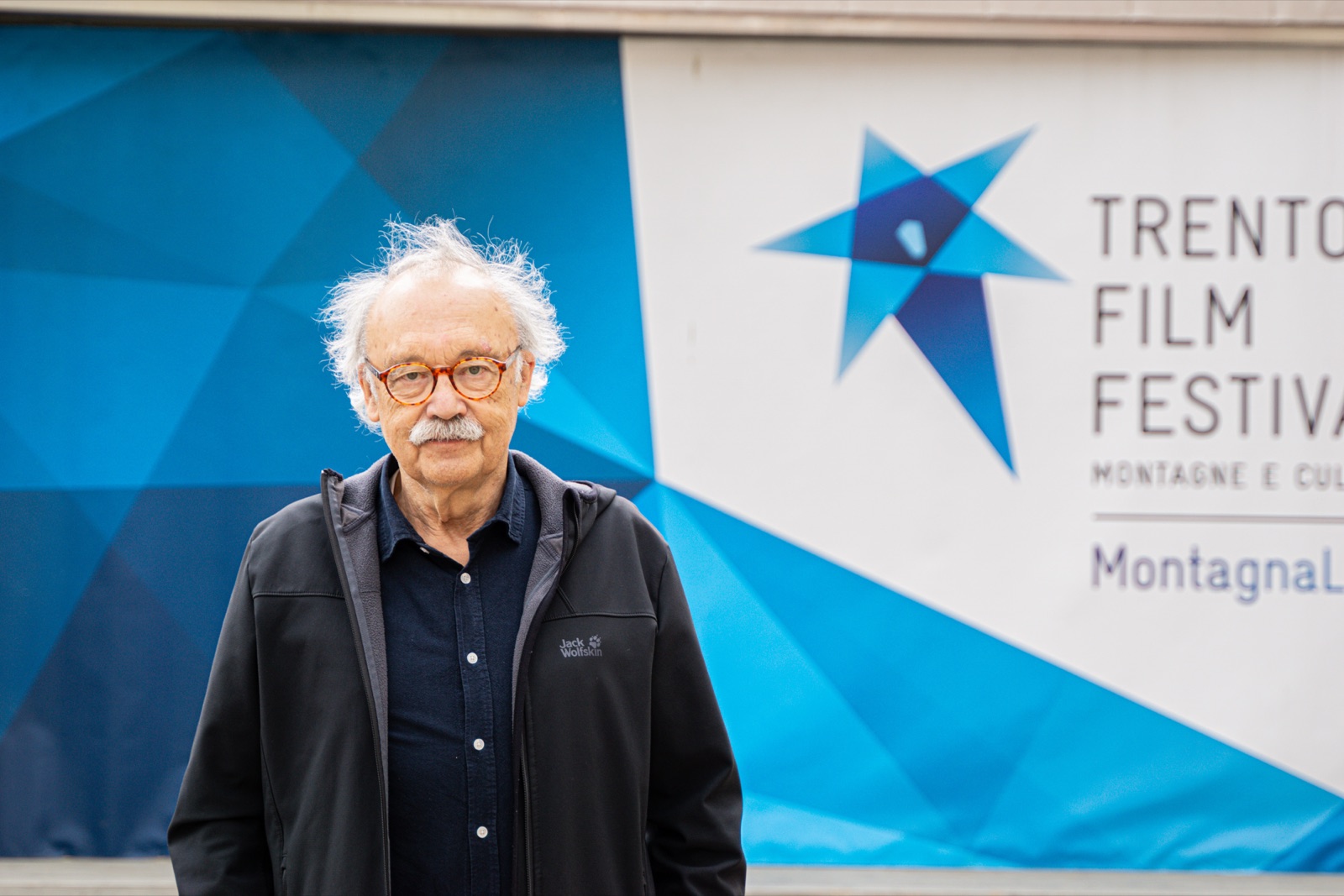 Un ospite davanti al logo del Trento Film Festival