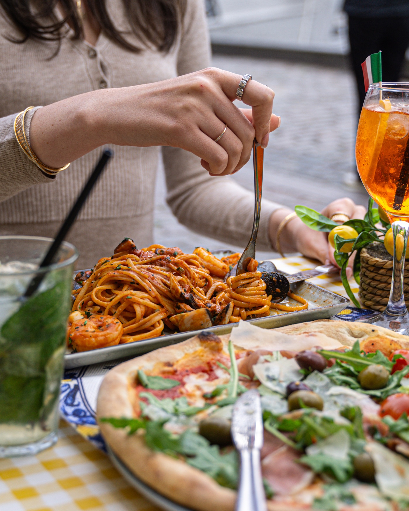 Tavola con pizza, pasta e spritz