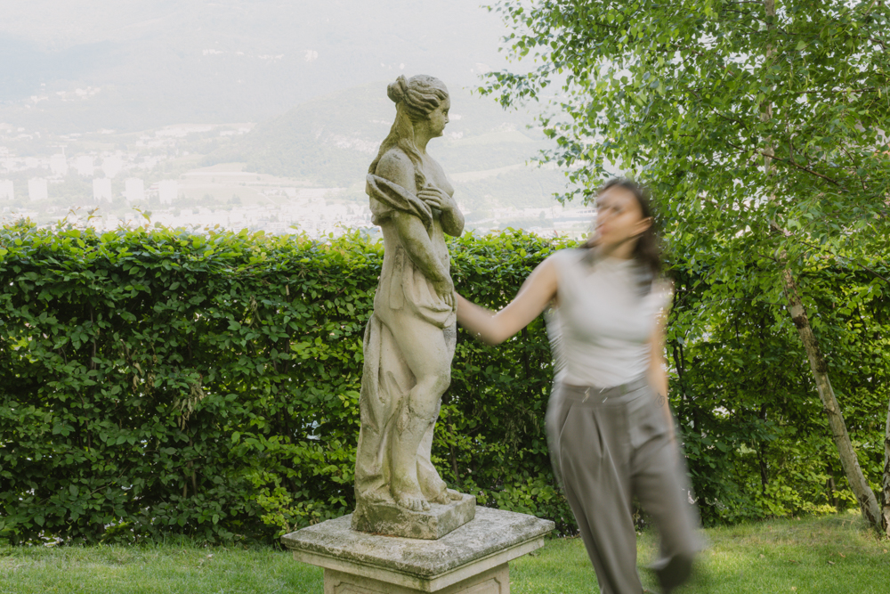 Una ragazza passa accanto alla statua in giardino